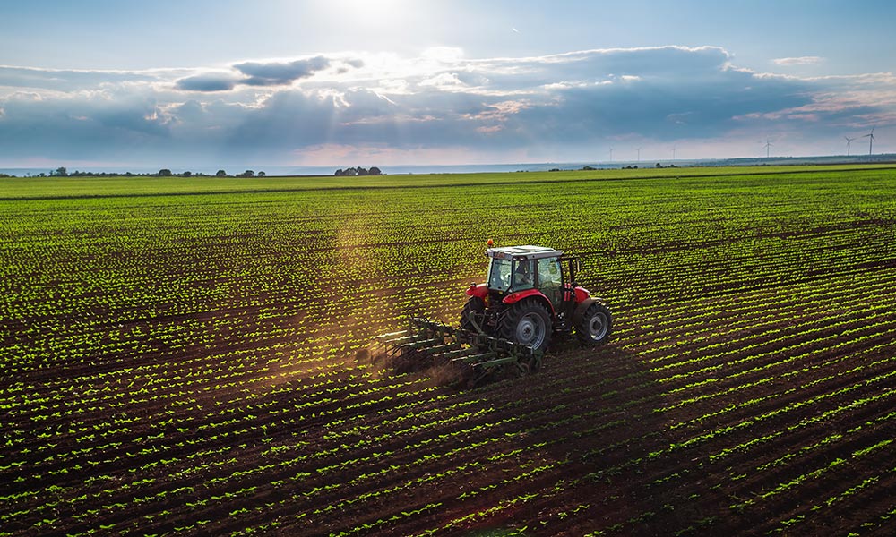 Tractor cultivating field at spring, aerial view