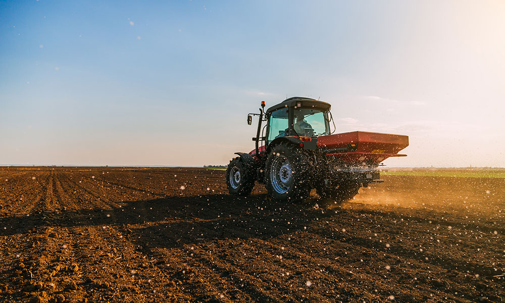 Farmer fertilizing arable land with nitrogen, phosphorus, potassium fertilizer